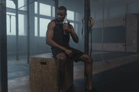Persona usando la pistola de masaje muscular tras entrenar